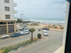 a view of a parking lot with cars and the beach at Appartement vu sur mer in Pont Blondin