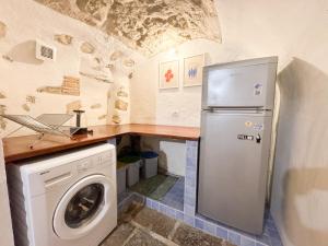 a kitchen with a refrigerator and a washing machine at Kalma Arched Loft - Unique Brick Vault in City Heart in Cagliari