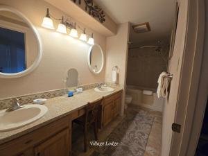 a bathroom with two sinks and a mirror at Village Lodge in Ruidoso