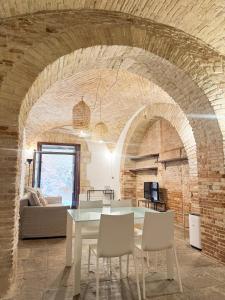 a dining room with a table and a brick wall at Kalma Arched Loft - Unique Brick Vault in City Heart in Cagliari