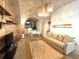 a living room with a couch and a table at Kalma Arched Loft - Unique Brick Vault in City Heart in Cagliari