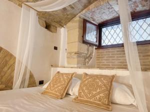 a bedroom with a white bed with a window at Kalma Arched Loft - Unique Brick Vault in City Heart in Cagliari