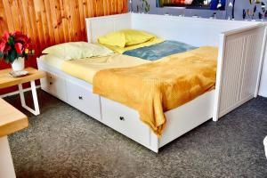 ein Schlafzimmer mit einem weißen Bett mit gelber Bettwäsche in der Unterkunft Gite Caribou in Besse-et-Saint-Anastaise