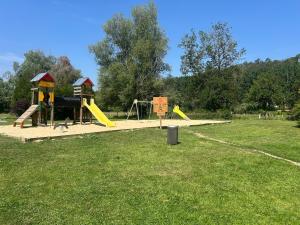 a park with a playground with a slide at Cozy bungalow in Ivry-la-Bataille