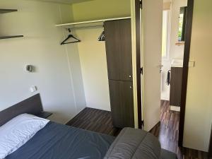 a small bedroom with a bed and a closet at Cozy bungalow in Ivry-la-Bataille