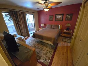 a bedroom with a bed and a chair and a window at Village Lodge in Ruidoso
