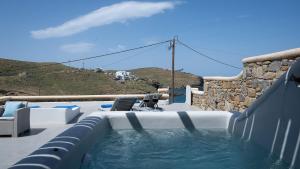 a swimming pool with a chair and avisor at Ultramare Mykonos Beachfront House with 2 Outdoor Tubs in Mykonos