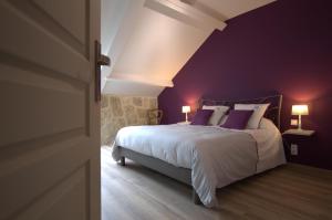 a bedroom with purple walls and a bed with purple pillows at Le jardin sainte anne in Balnot-sur-Laignes