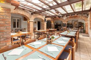 un ristorante con tavoli e sedie e un muro di mattoni di Ražman Wine Rooms a Gračišče