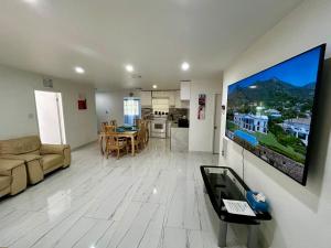 a living room with a couch and a tv on a wall at Bright & Cozy House Fort Lauderdale Airport-Cruise Port in Dania Beach