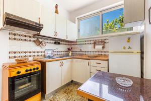 a kitchen with white cabinets and a stove top oven at Salentoandmore - Villetta Salento in Marina San Gregorio +25 photos
