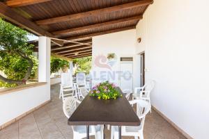 a wooden table and chairs on a patio at Salentoandmore - Villetta Salento in Marina San Gregorio
