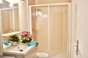ein Badezimmer mit Dusche und Waschbecken mit Blumen in der Unterkunft Gite Caribou in Besse-et-Saint-Anastaise + 31 Fotos