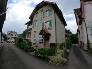 a white house with green shutters on a street at Harderblick in Interlaken
