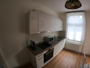 a kitchen with white cabinets and a sink and a microwave at Harderblick in Interlaken