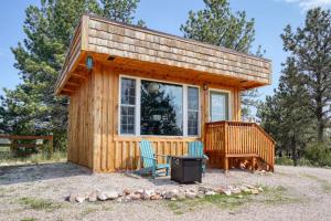 Una pequeña casa con dos sillas y una estufa. en Columbine Cabin at Highland Meadows, en Hot Springs