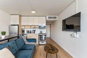 a living room with a blue couch and a kitchen at Modern Mountain View Downtown Oasis Free Pkg Gym in Salt Lake City