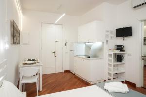 a small white kitchen with a table and a desk at Due metri sopra al mare in Otranto +11 photos