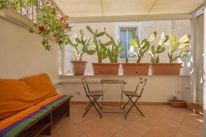 a room with a table and chairs and potted plants at Lydian Suite in Bari