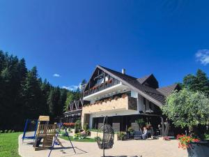 a building with a playground in front of it at Rarău Retreat in Câmpulung Moldovenesc