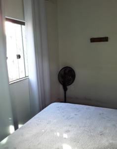 a bedroom with a white bed and a window at Pouso Vista da Serra in São João del Rei