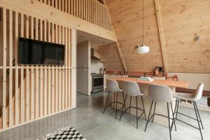 a kitchen with wooden walls and a bar with stools at Canadian Classic - Spa - Sauna - Fire - Forest in Val-David