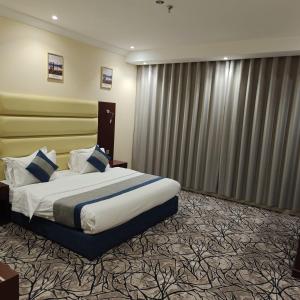 a hotel room with a large bed and curtains at برج الذهبية للشقق المخدومة in Taif