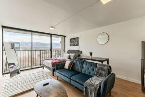 a living room with a couch and a large window at The White Mountain View Downtown Studio Apt Free Pkg Gym in Salt Lake City
