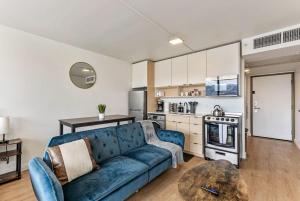 a living room with a blue couch and a kitchen at The White Mountain View Downtown Studio Apt Free Pkg Gym in Salt Lake City