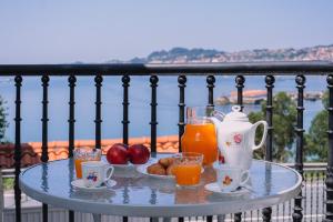 a table with a tray of juice and fruit on a balcony at Vistas de lujo al lado del mar by CABANA Rentals in Moaña