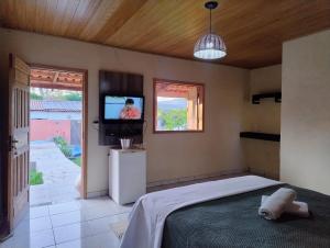 una camera da letto con un letto e una TV a schermo piatto di Veraneio Recanto dos Ipês a Pirenópolis