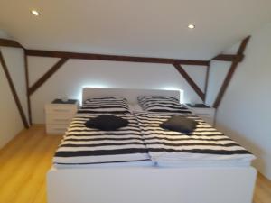 a bed with black and white striped sheets in a room at Haus Helmuth in Süderdeich