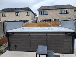 a hot tub on a patio with two chairs at PARADISE SHARED SHORT STAy in Bowmanville