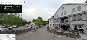 a street with a building and cars parked in a parking lot at Beechwood Lodge - B in Ballybofey