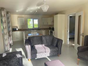 a living room with a couch and a kitchen at Beechwood Lodge - B in Ballybofey +11 photos