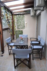 a patio with two chairs and a wooden table at Oikia Samiotaki Emmanouil in Sarti