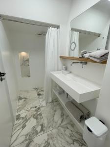a white bathroom with a sink and a mirror at LutherStudios in Schleswig