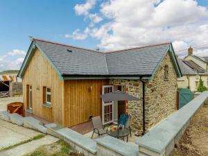 a small stone house with a table and an umbrella at 1 Bed in Westward Ho 87347 in Littleham