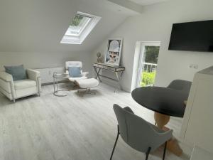 a living room with a table and chairs and a mirror at LutherStudios in Schleswig