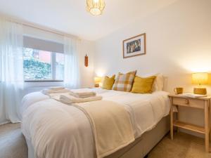 a bedroom with a large white bed and a window at 3 Bed in Braunton 86042 in Braunton