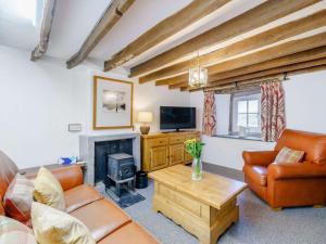 a living room with leather furniture and a fireplace at 4 Bed in Keswick 86250 in Threlkeld