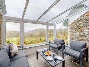 a living room with a couch and chairs and windows at 4 Bed in Keswick 86250 in Threlkeld