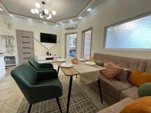 ein Wohnzimmer mit einer Couch und einem Tisch und Stühlen in der Unterkunft Двухкомнатная квартира в Аркадии с двумя кроватями две отдельные спальни in Odessa