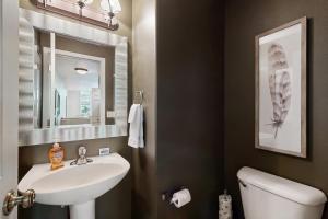 a bathroom with a sink and a toilet and a mirror at Fox Hollow Home in Whitefish +18 photos