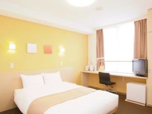 a hotel room with a bed and a desk and a television at Quad Inn Yokote - Vacation STAY 57366v in Yokote