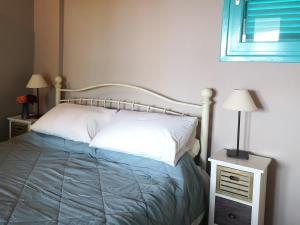 a bedroom with a bed and two night stands and a window at The Iconpainter Zaga Villa in Kómboi