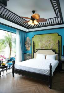 a bedroom with a bed and a ceiling fan at Tam Coc Ecolodge in Vũ Lâm