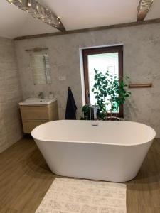 eine große weiße Badewanne im Bad mit Waschbecken in der Unterkunft Stonava-Mexiko, industry&pohoda-klid in Karviná