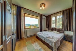 a bedroom with a bed and a large window at При Баръма in Vishnevo