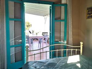 a bedroom with a door open to a balcony at The Iconpainter Zaga Villa in Kómboi